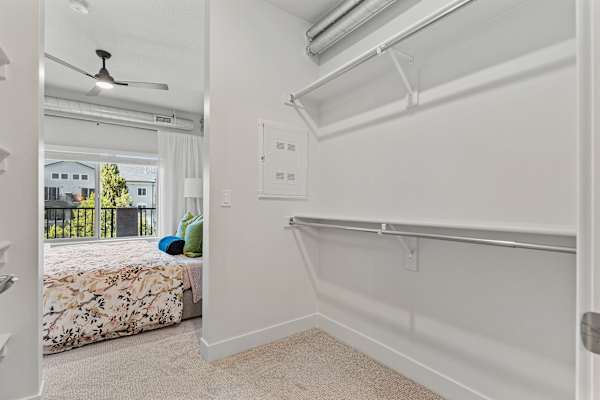 A white bedroom with a bed, a window, a fan, and a chair. at The Revival, Salt Lake City